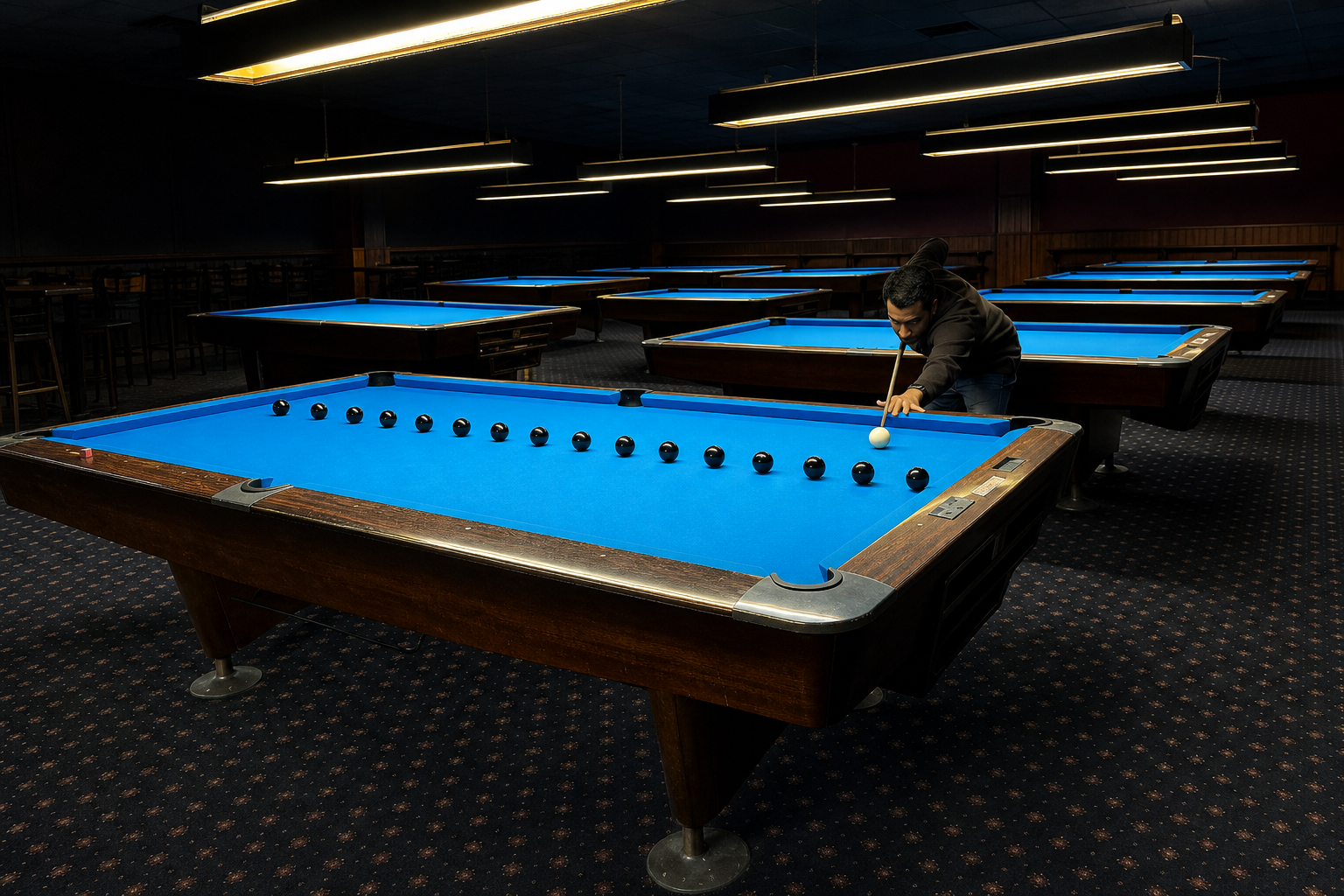 Player aiming a cream cue ball toward a practice line of fifteen black 8-balls on a blue table in a dim pool hall